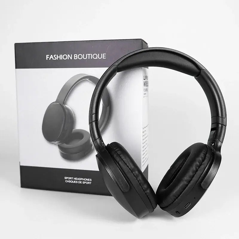 Black sport headphones beside their packaging on a white background.